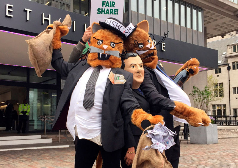 © Reuters. Protestors wearing costumes pose outside the venue for the HSBC AGM in London