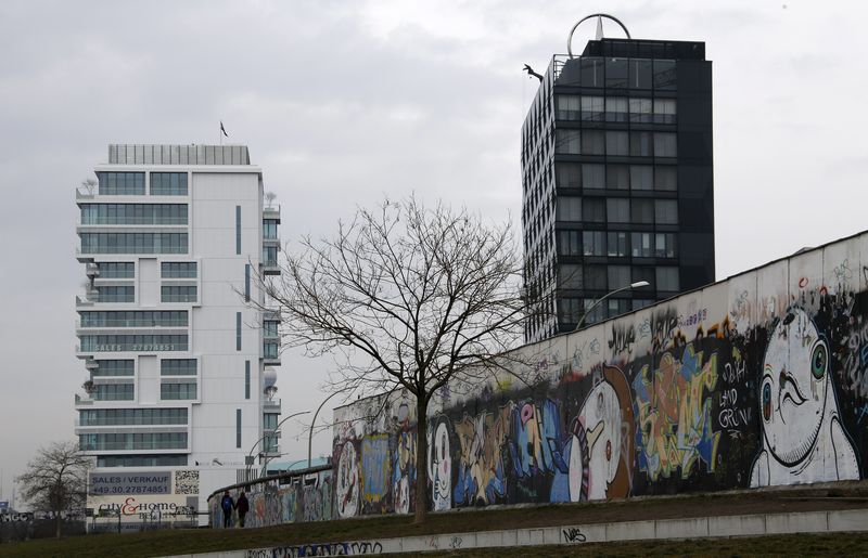 © Reuters. A luxury apartment building (L) is pictured beside sections at the East Side Gallery, the largest remaining part of the former Berlin Wall in Berlin