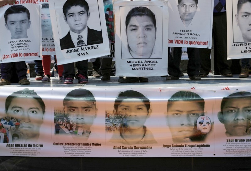 © Reuters. Relatives hold up posters during a rally in support of missing students from Ayotzinapa Teacher Training College, at the National Autonomous University of Mexico (UNAM) in Mexico City