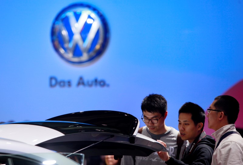 © Reuters. Visitantes miran un vehículo de Volkswagen durante el día para la prensa en la Feria Internacional de la Industria Automotriz de Shanghái 2013 en Shanghái