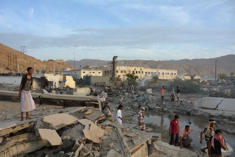 © Reuters. People inspect damage at a site hit by Saudi-led air strikes in the al Qaeda-held port of Mukalla city in southern Yemen