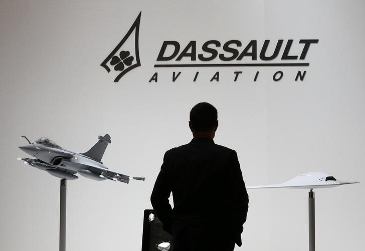 © Reuters. A file photo shows a visitor who looks at replicas of the fighter jet Rafale and Neuron on the Dassault booth during the EBACE in Geneva