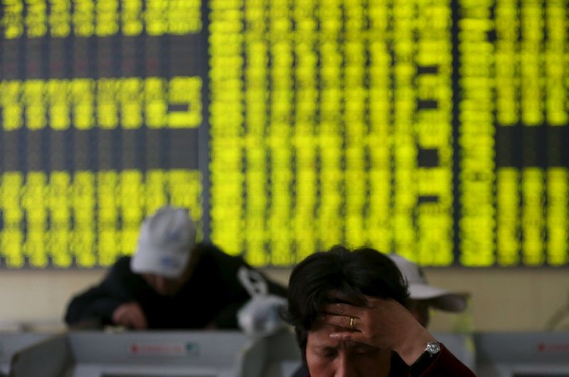 © Reuters. Investors check stock information at a brokerage house in Nantong