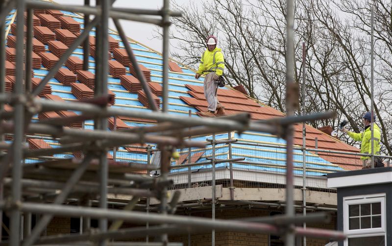 © Reuters. Construction workers build a new residential property development in north London
