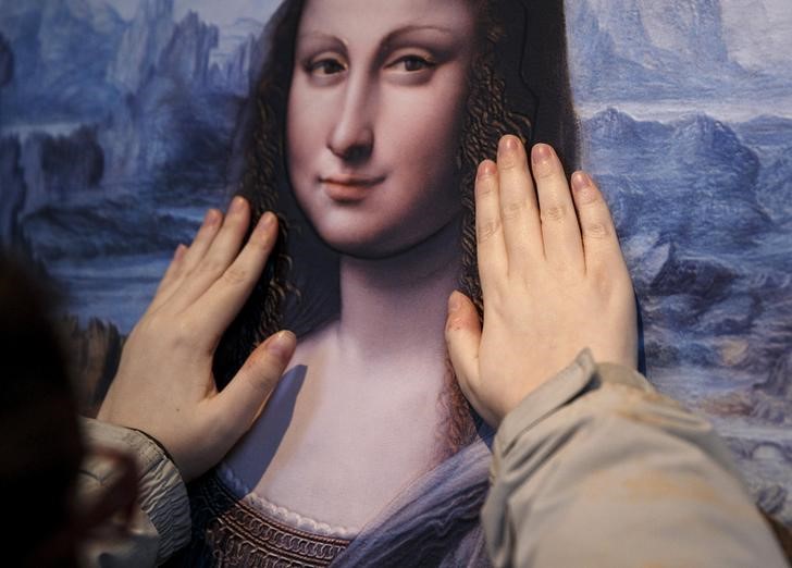 © Reuters. Visitante do Museu do Prado, em Madri, toca obra Mona Lisa