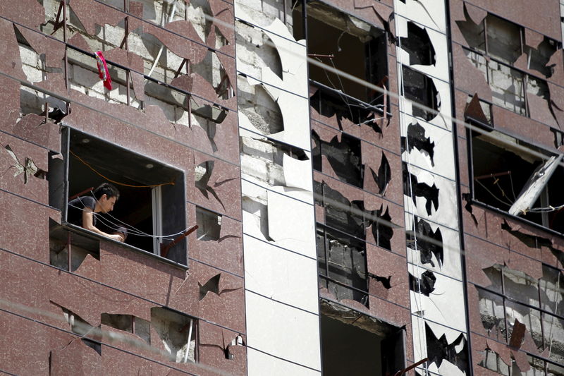 © Reuters. Homem observa janelas quebradas após explosão de carro-bomba no sul de Damasco