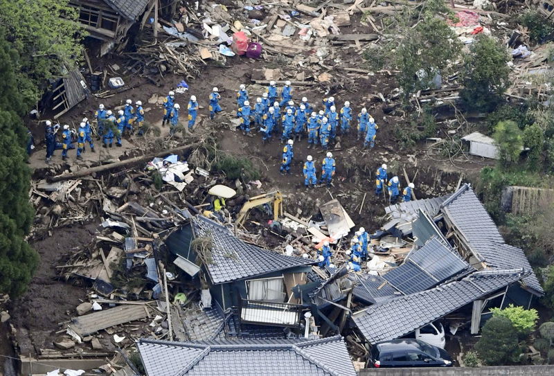 © Reuters. Rescue workers conduct a search and rescue operation to a collapsed house at a landslide site caused by earthquakes in Minamiaso town, Japan