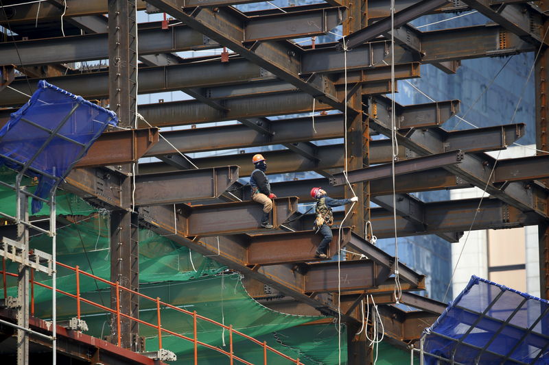 © Reuters. Workers labour on a steel frame at a construction site in central Seoul