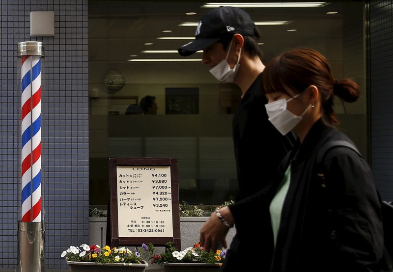 © Reuters. People walks past a barber store in Tokyo