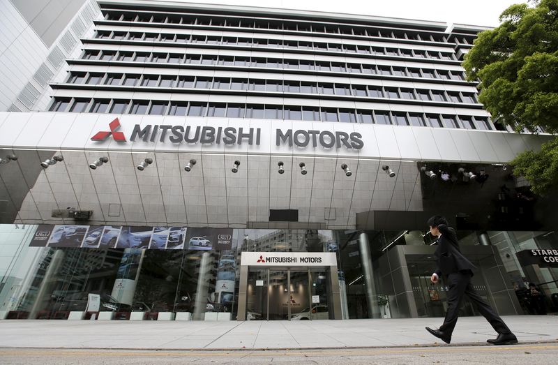 © Reuters. Man walks in front of Mitsubishi Motors Corp's headquarters in Tokyo