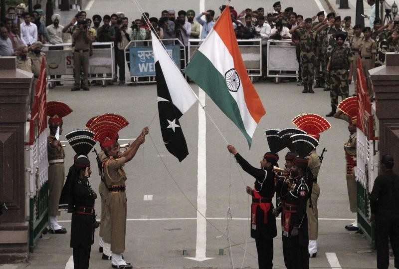 © Reuters. Pakistani rangers and Indian Border Security Force officers lower their national flags during a daily parade at the Pakistan-India joint check-post at Wagah