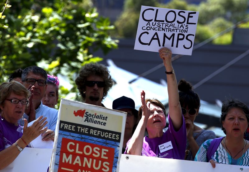 © Reuters. File photo of protesters reacting as they hold placards and listen to speakers during a rally in support of refugees in central Sydney, Australia