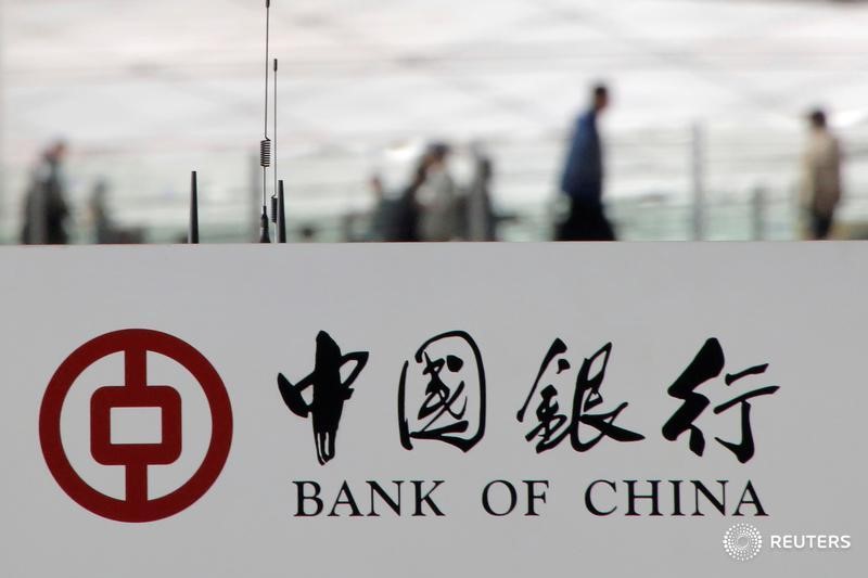 © Reuters. Пешеходы за логотипом Bank of China в Пекине