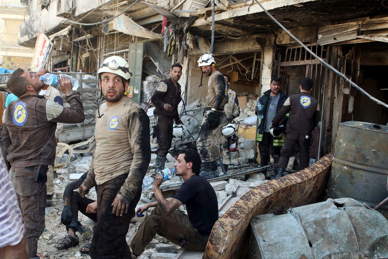 © Reuters. Civil defence members rest amid rubble of damaged buildings after an airstrike on the rebel-held Tariq al-Bab neighbourhood of Aleppo