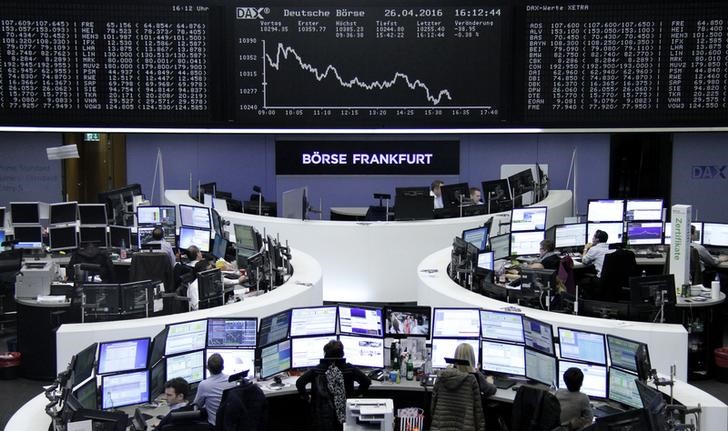 © Reuters. Traders work at their desks in front of the German share price index, DAX board, at the stock exchange in Frankfurt