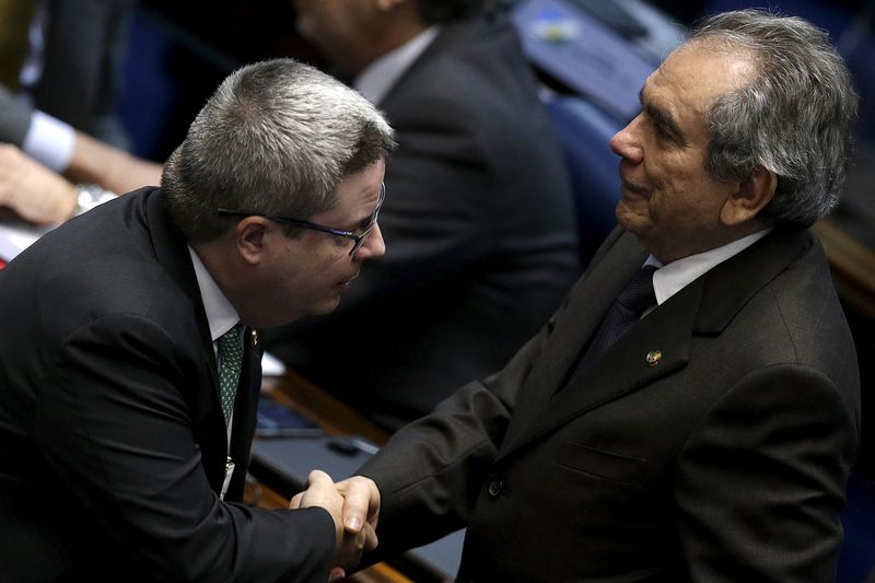 © Reuters. Relator da comissão do impeachment no Senado, Antonio Anastasia (D), cumprimenta o presidente do colegiado, senador Raimundo Lira (E), no plenário da Casa, em Brasília