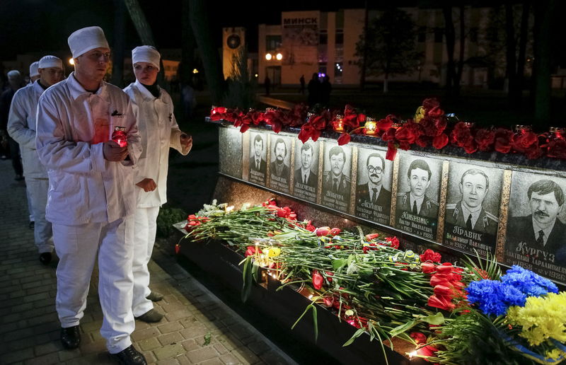 © Reuters. Funcionários da usina nuclear de Chernobyl seguram velas em visita a memorial dedicado a bombeiros e trabalhadores que morreram após o desastre, na cidade de Slavutych, na Ucrânia 