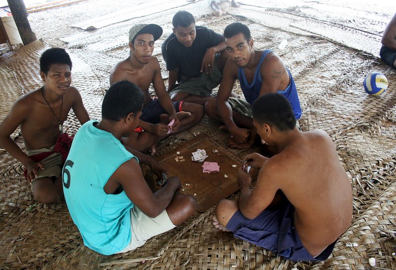 © Reuters. Prisoners play cards under a shelter located in a prison on Kiritimati Island, part of the Pacific Island nation of Kiribati