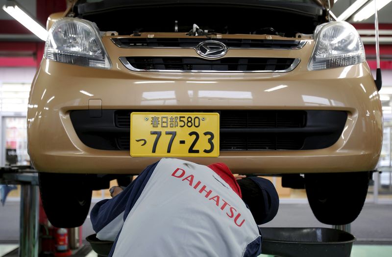 © Reuters. An engineer works under a Daihatsu Motor Co.'s Move vehicle at the company's dealership in Tokyo
