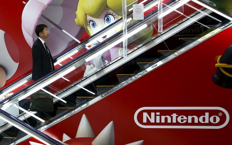 © Reuters. A man rides an escalator past an advertisement of the Nintendo Co videogame maker at an electronic retailer in Tokyo