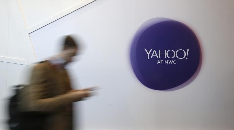 © Reuters. A man walks past a Yahoo logo during the Mobile World Congress in Barcelona