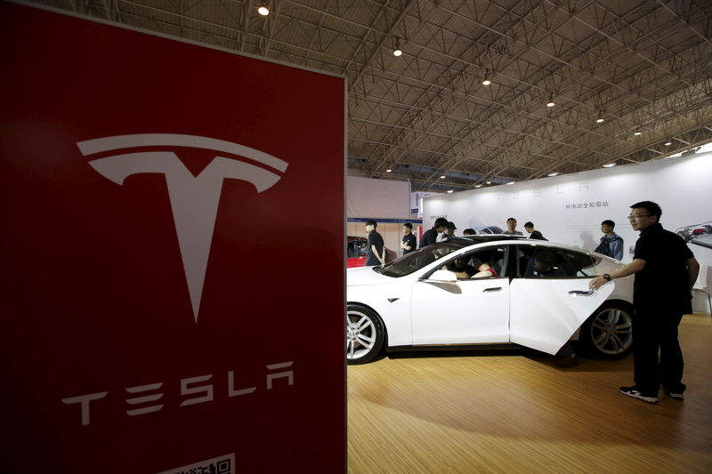 © Reuters. People visit a Tesla Model S car during the Auto China 2016 in Beijing