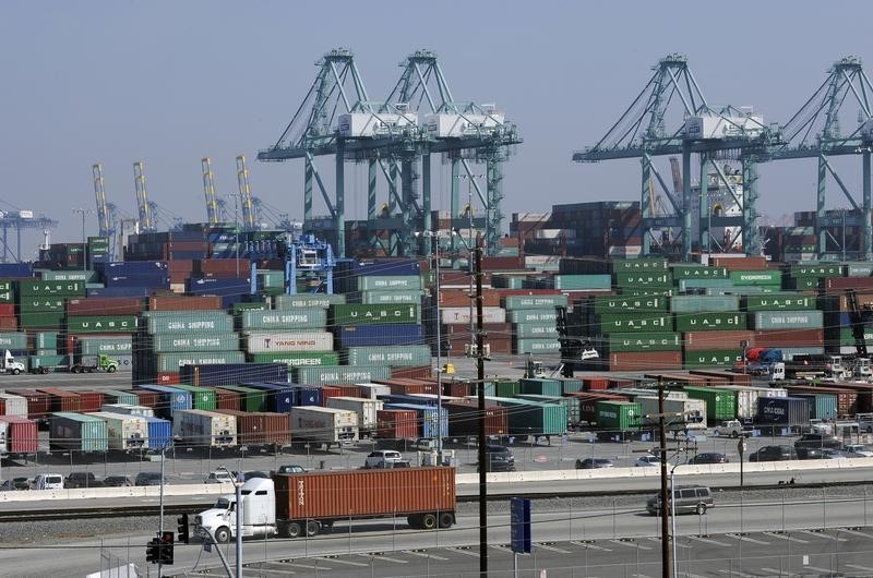 © Reuters. Freighters and cargo containers sit idle at the Port of Los Angeles as a back-log of over 30 container ships sit anchored outside the Port in Los Angeles