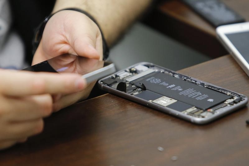 © Reuters. A worker checks an iPhone in a repair store in New York