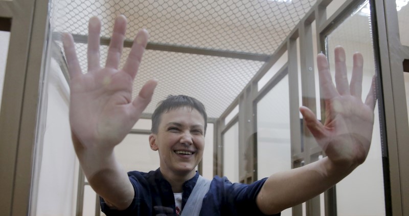 © Reuters. Former Ukrainian army pilot Savchenko gestures from inside a glass-walled cage during verdict hearing at court in Donetsk in Rostov region