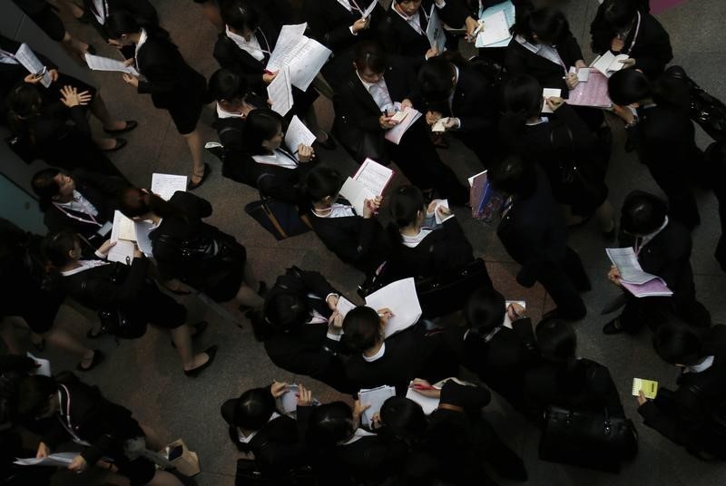 © Reuters. Job seekers stand outside a job fair event room at a commercial building in Tokyo