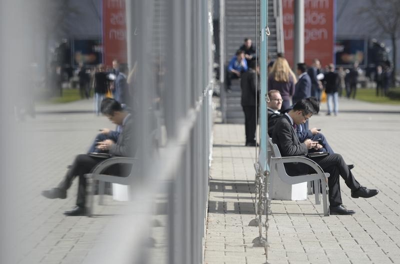 © Reuters. Visitors check their smartphones at the world's biggest computer and software fair CeBit in Hanover