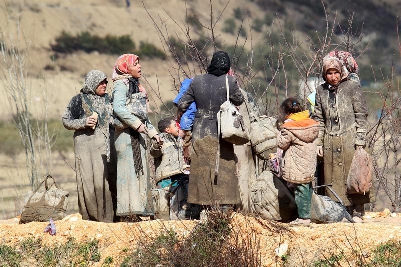 © Reuters. Internally displaced people, covered with mud, wait as they are stuck in the town of Khirbet Al-Joz, in Latakia countryside, waiting to get permission to cross into Turkey near the Syrian-Turkish border