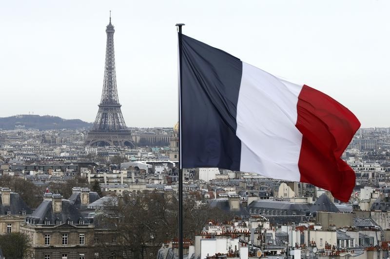 © Reuters. A French flag waves above the skyline as the Eiffel Tower in Paris 