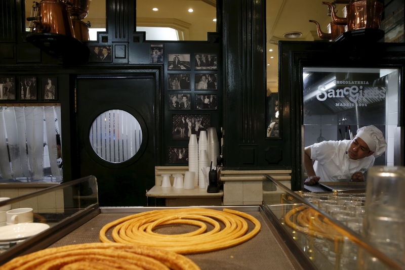 © Reuters. File photo of cook Christian Santana checking to see if more churros are needed during breakfast time at the Chocolate Shop San Gines in Madrid