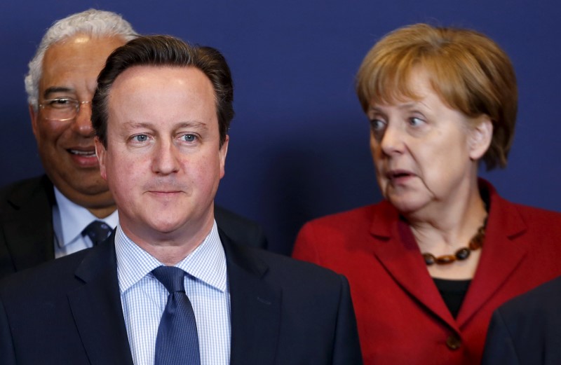 © Reuters. Britain's PM Cameron and Germany's Chancellor Merkel pose for a family photo during a EU leaders summit over migration in Brussels