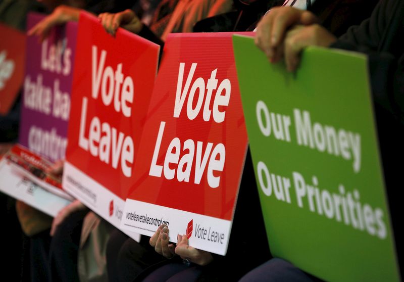 © Reuters. Supporters hold signs during the event where Mayor of London Boris Johnson was speaking during a Vote Leave rally in Manchester