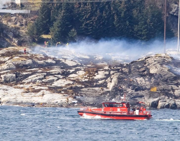 © Reuters. Команда спасателей реботает на месте крушения вертолета в Норвегии