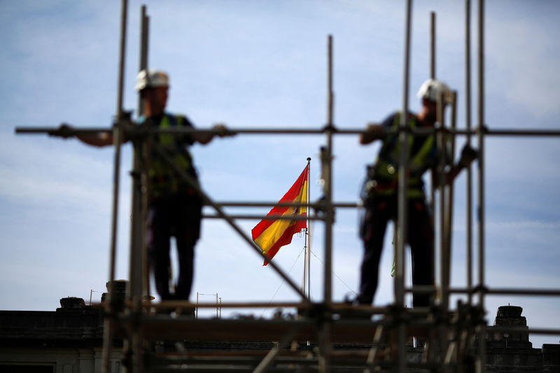 © Reuters. Workers build a pipe structure on a scaffolding during the World Day for Safety and Health at Work in the Andalusian capital of Seville