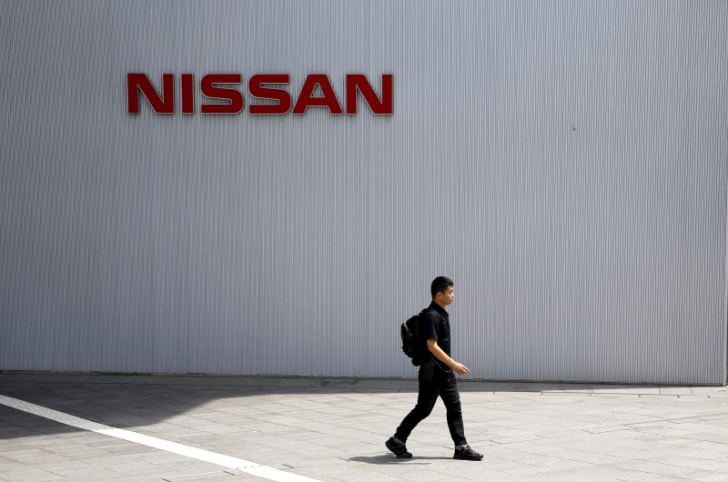 © Reuters. Man walks past logo of Nissan Motor Co. at the company's showroom in Yokohama