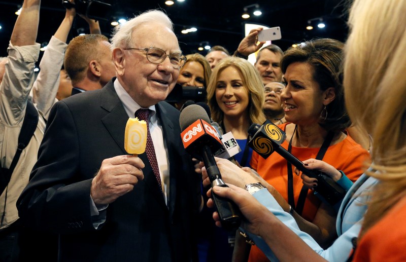 © Reuters. Berkshire Hathaway CEO Buffett talks to reporters while holding an ice cream at a trade show during the company's annual meeting in Omaha