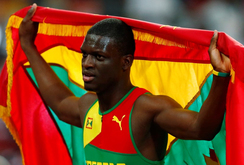 © Reuters. James holds his national flag after placing third in the men's 400 metres final at the IAAF World Championships in Beijing