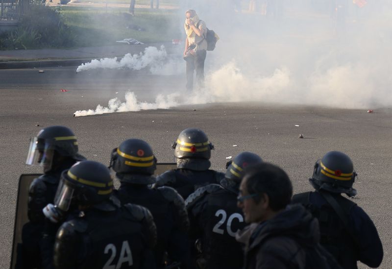 © Reuters. French CRS riot police secure a position as clouds of tear gas fill the Place de la Nation during clashes with youths who protest against the French labour law proposal during the May Day labour union march in Paris