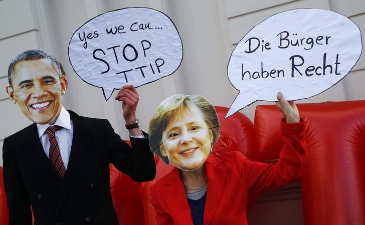 © Reuters. Protesters wear masks of U.S. President Obama and German Chancellor Merkel to demonstrate against TTIP free trade agreement before the opening ceremony of the Hannover Messe in Hanover