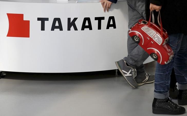 © Reuters. File photo of visitors walking past a logo of Takata Corp on its display at a showroom for vehicles in Tokyo