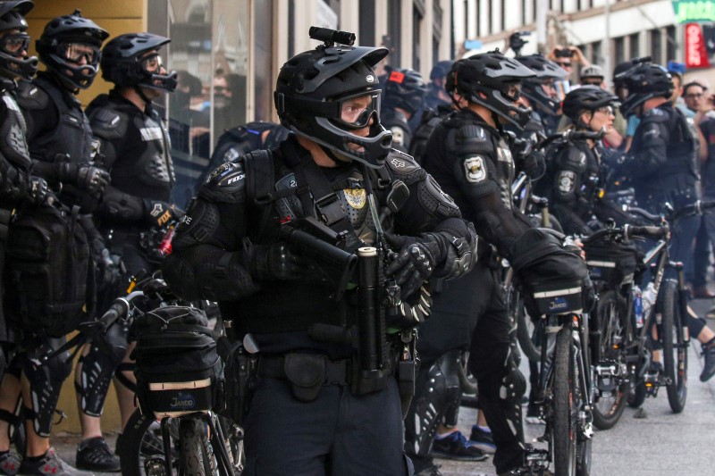 © Reuters. A police officer reloads after firing a nonlethal weapon into a crowd during anti-capitalist protests following May Day marches in Seattle