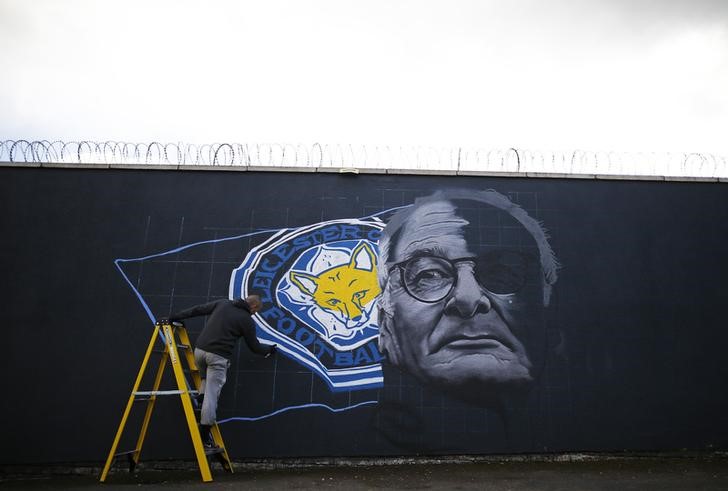 © Reuters. Artist Richard Wilson spray paints a mural of Leicester City manager Claudio Ranieri in Leicester