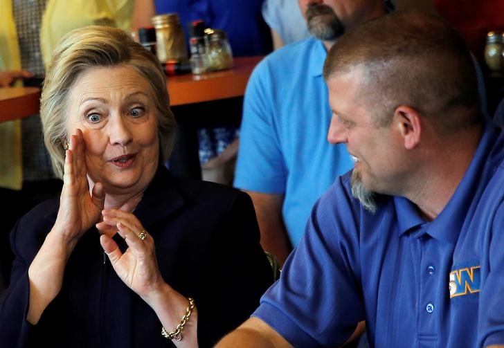 © Reuters. Hillary Clinton conversa com trabalhador em Ashland