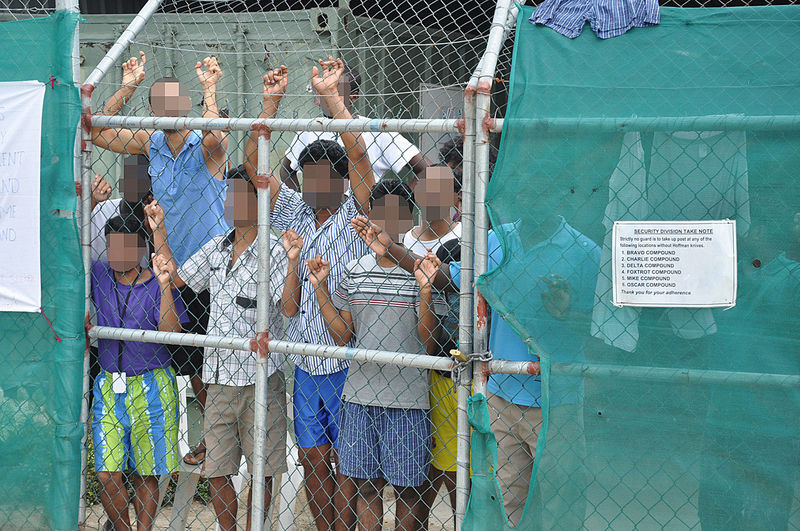 © Reuters. Asylum-seekers look through a fence at the Manus Island detention centre in Papua New Guinea