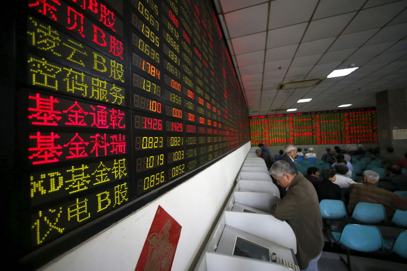 © Reuters. Investors look at computer screens showing stock information at a brokerage house in Shanghai