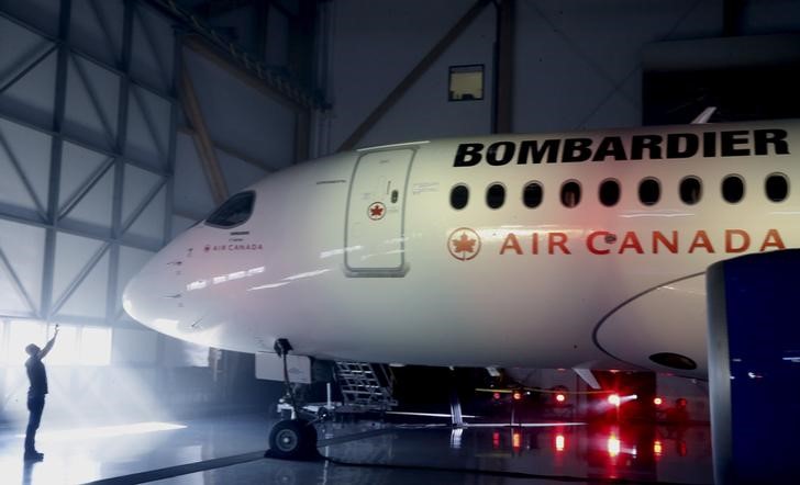 © Reuters. A man takes a photo of a Bombardier CSeries100 aircraft prior to a news conference in Montreal